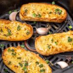 Air fryer full of hot dog bun turned garlic breads.