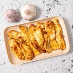 Air fried hot honey halloumi slices on a tray.
