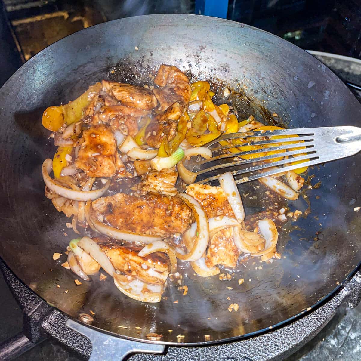 Chicken is stir fried in black pepper sauce.