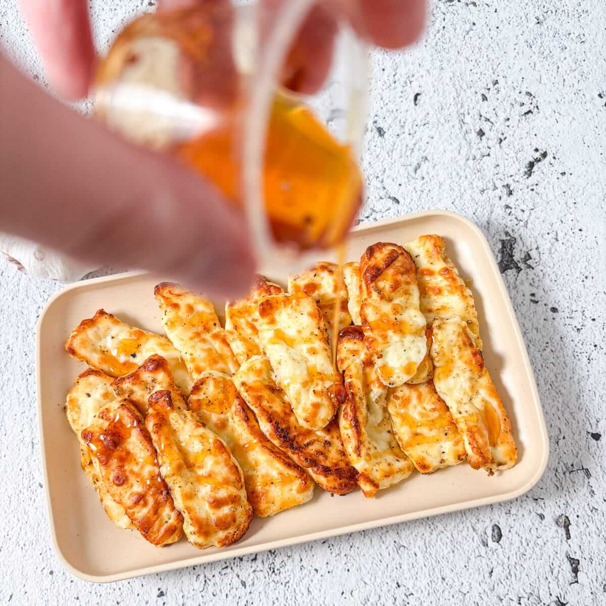 Hot honey is drizzled over the fried halloumi.