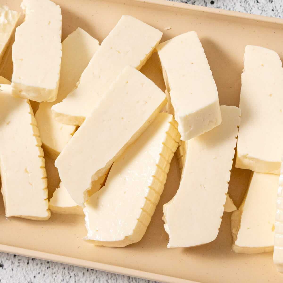 Sliced halloumi cheese on a tray.